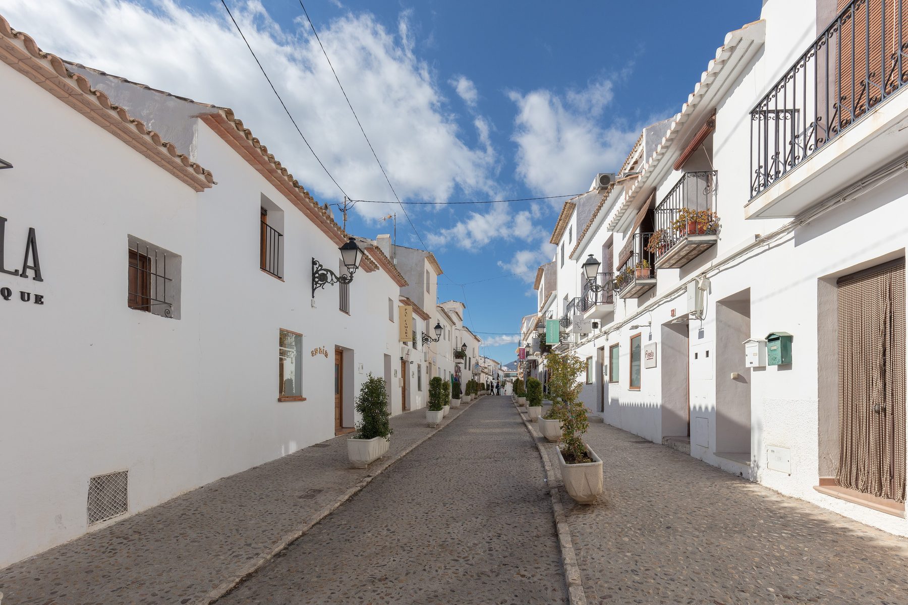 Calle empedrada del casco antiguo de Altea con fachadas encaladas