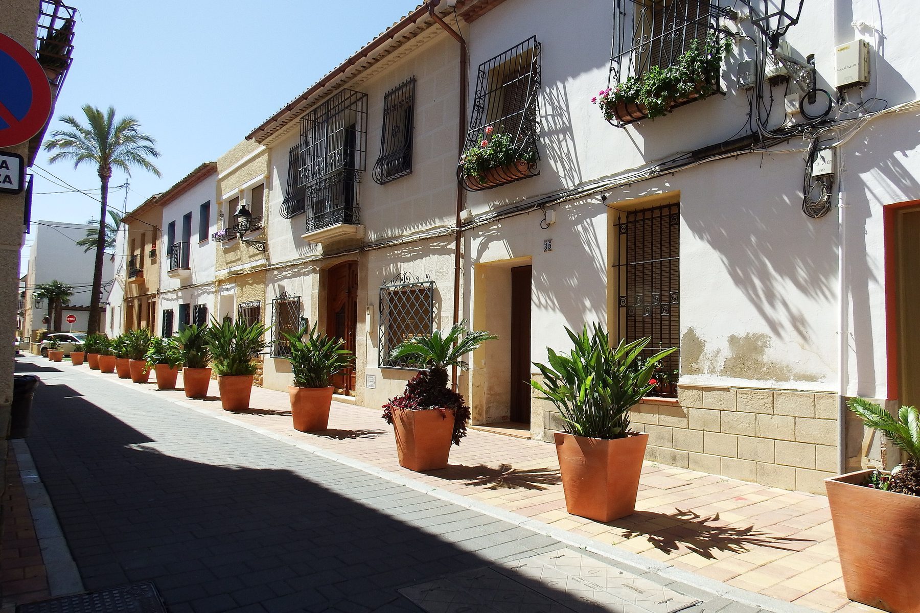 Calle del núcleo histórico de La Nucía, con macetas en las fachadas encaladas